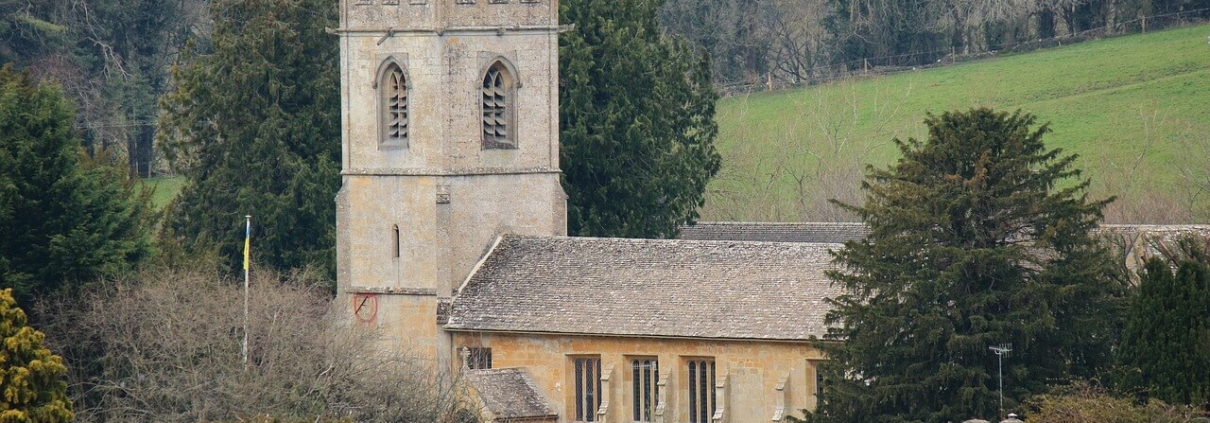 Old stone church in the country surrounded by trees.