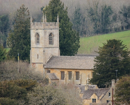 Old stone church in the country surrounded by trees.