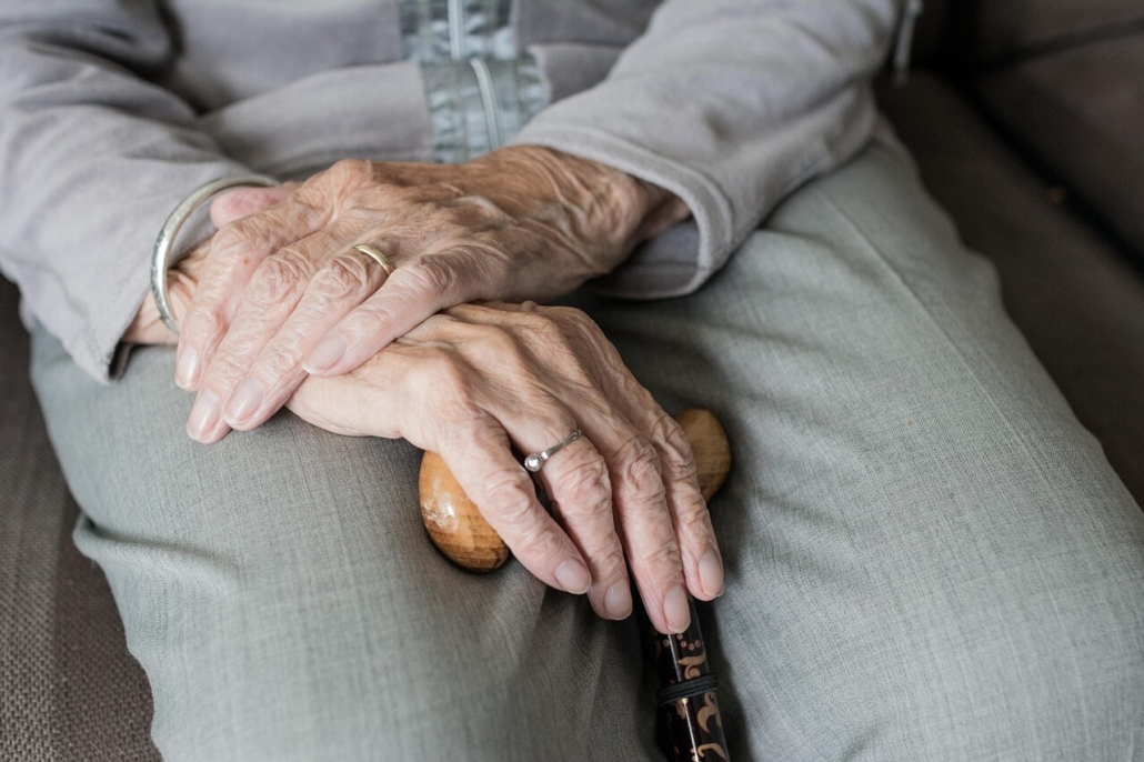 An older woman with her hands in her lap.