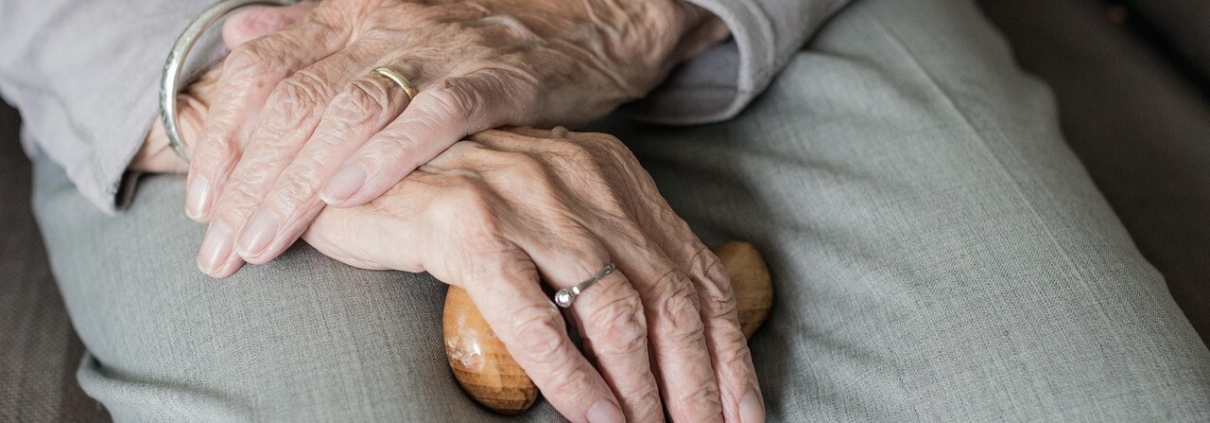 An older woman with her hands in her lap.