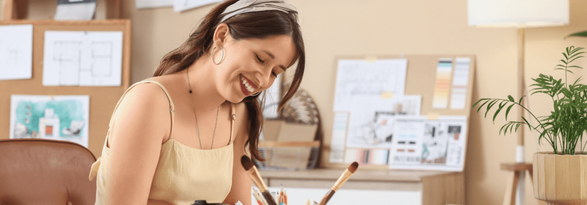 woman sitting at desk with crafting supplies.