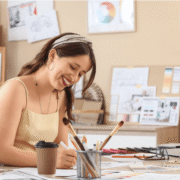 woman sitting at desk with crafting supplies.