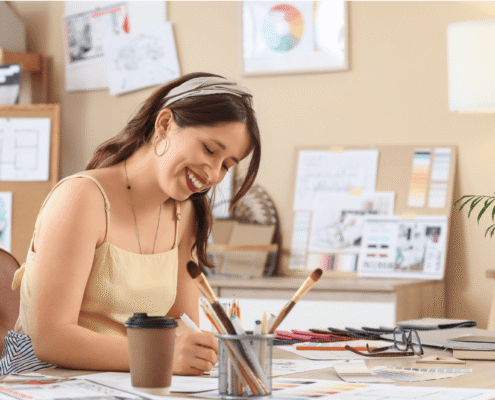 woman sitting at desk with crafting supplies.